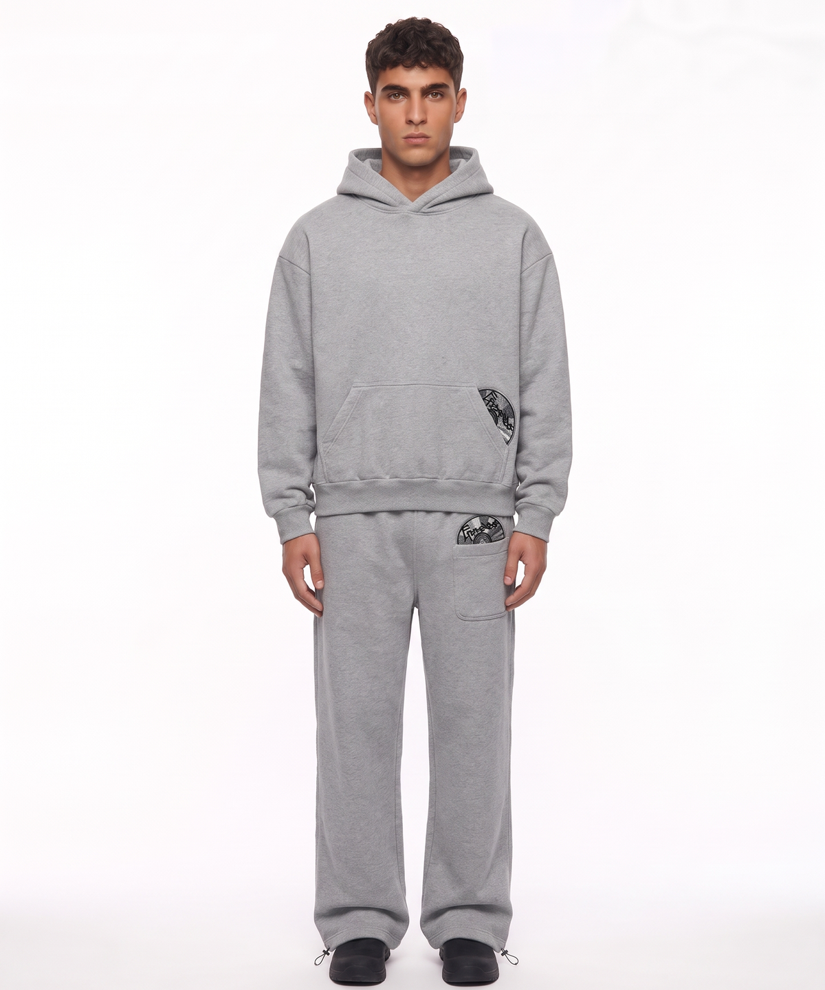 ECHO - TRACKSUIT in Grau, getragen von einem Model, Hoodie und Jogger im Set