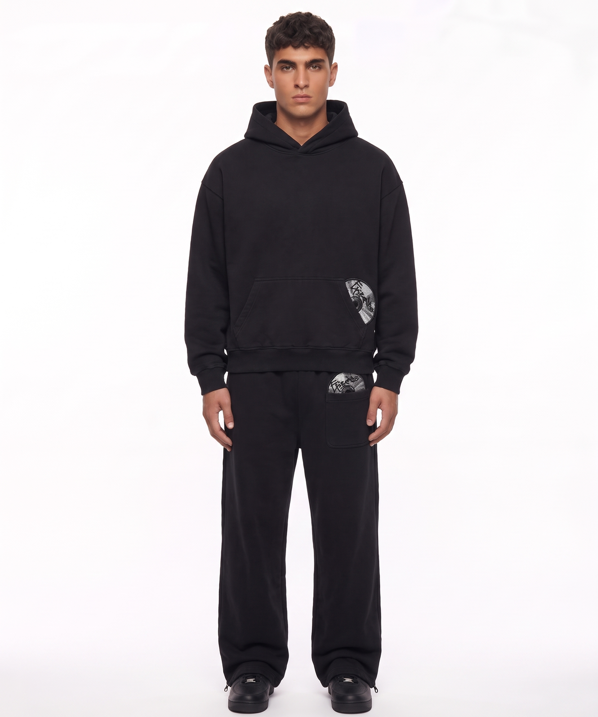 ECHO - TRACKSUIT in Schwarz, getragen von einem Model, Hoodie und Jogger im Set