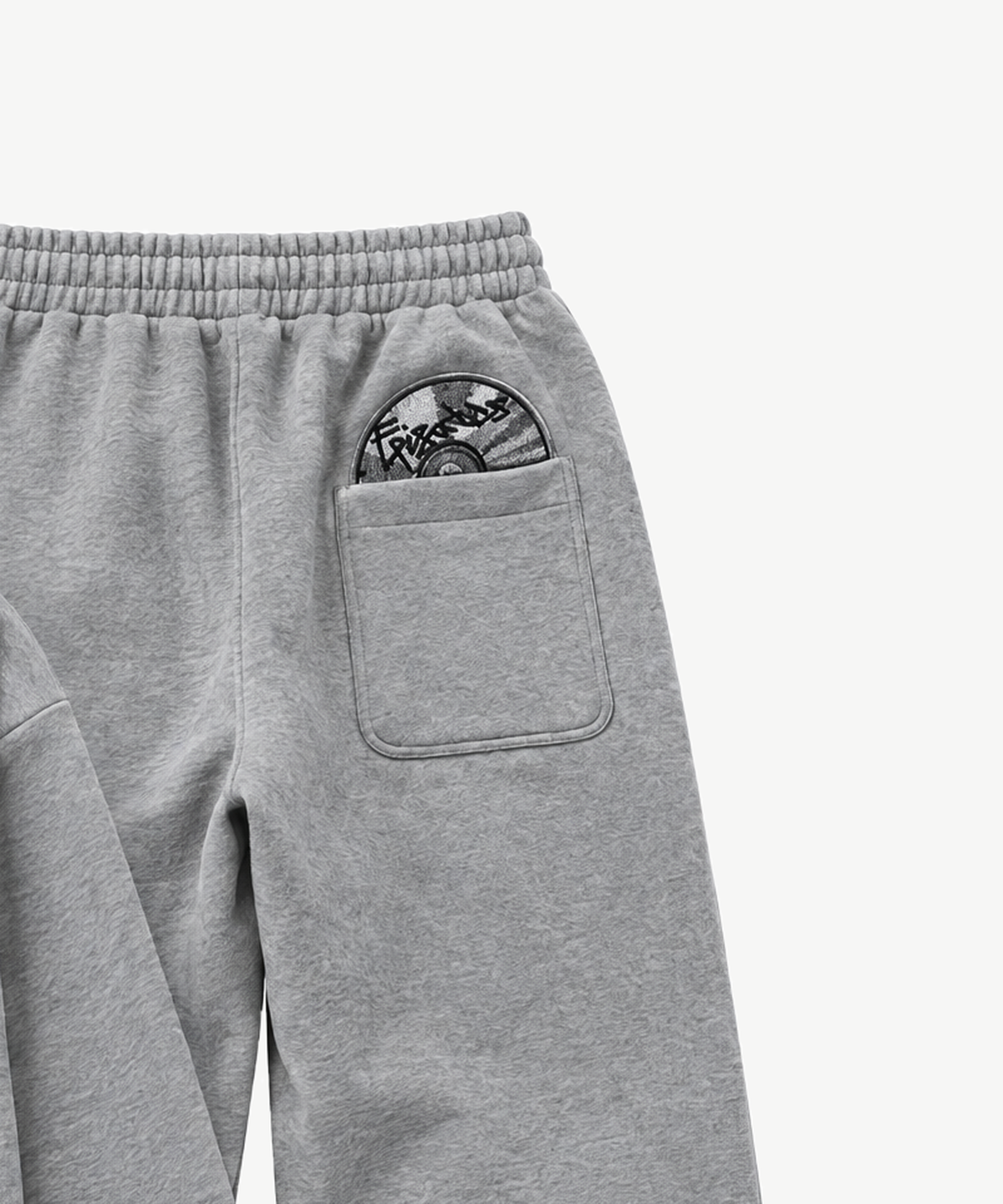 ECHO - TRACKSUIT in Grau, Detailansicht des gestickten Patches an der Jogger