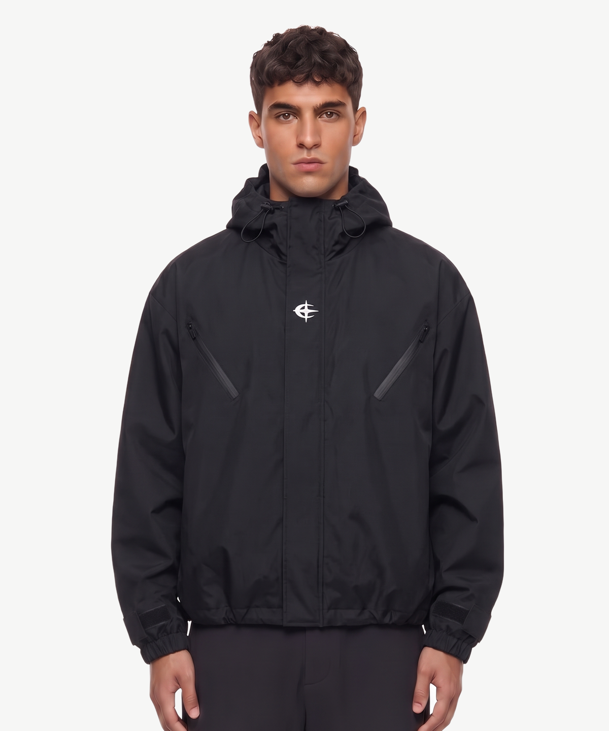 ORBIT - JACKE in Schwarz, getragen von einem Model, mit kleinem weißem Logo auf der Brust