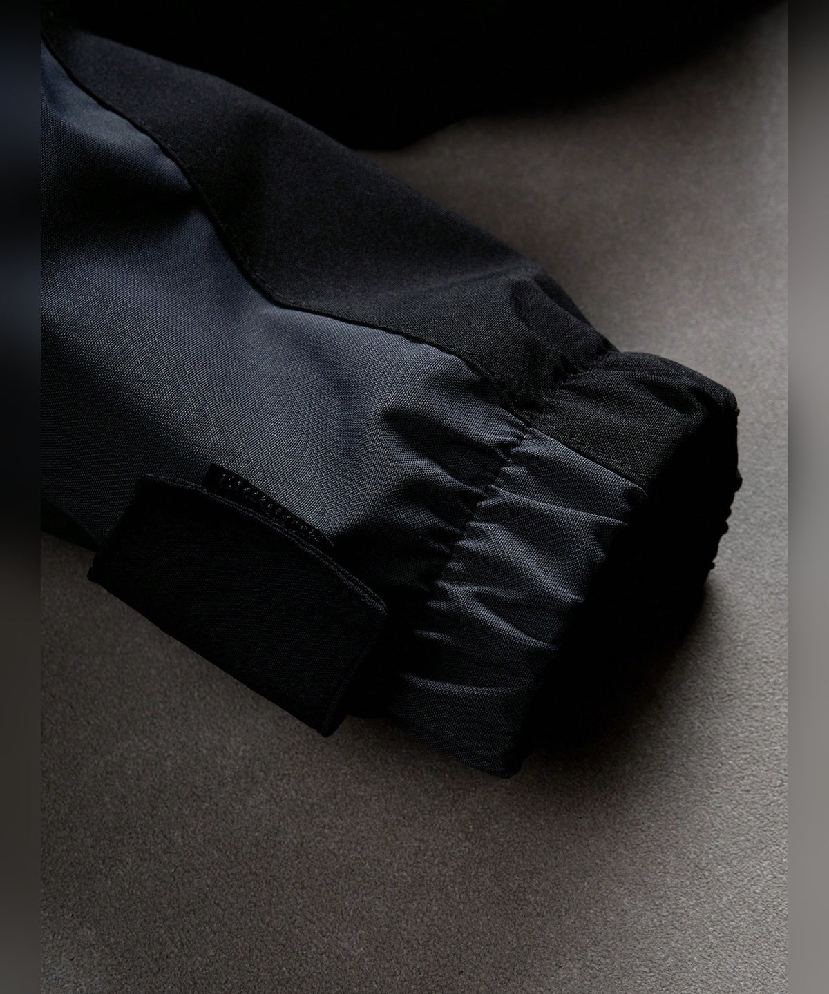 VERTEX - JACKE in Schwarz, Nahaufnahme Ärmelbündchen mit Klettverschluss